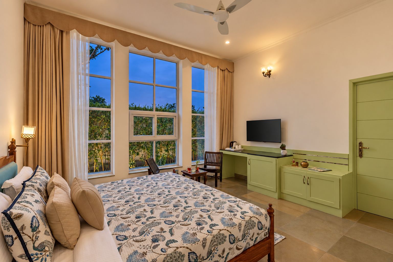 Un dormitorio con cama, escritorio y televisor.