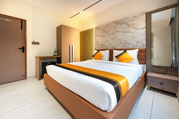 Une chambre d’hôtel moderne avec un grand lit, une table de chevet, un miroir et une armoire.