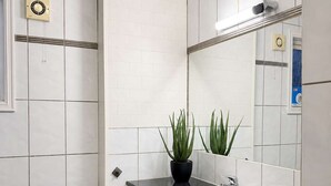 Un bagno moderno con il water bianco, un lavabo con piano nero e uno specchio sopra il lavabo.