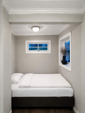 A bedroom with a single bed, a window with a view, and a ceiling light fixture. - Central Haugesund Villa: Free Parking & Fast WiFi (Haugesund)