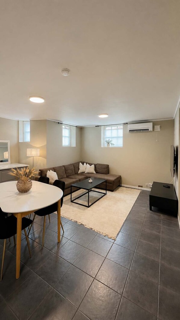A modern living room with a sofa, coffee table, and dining area. - Central Haugesund Apt w/ Free Parking & Fast WiFi (Haugesund)