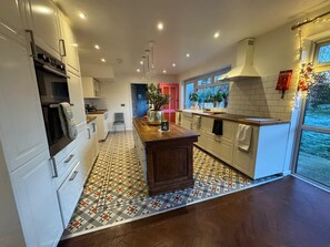 A modern kitchen with white cabinets, a wooden island, and a patterned floor.
