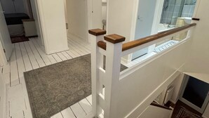 Een trap met een houten leuning en een bekleed landingsvlak.