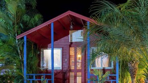 A two-story building with a red roof and blue accents, surrounded by lush greenery. - Eco Holiday Resorts (Indore)