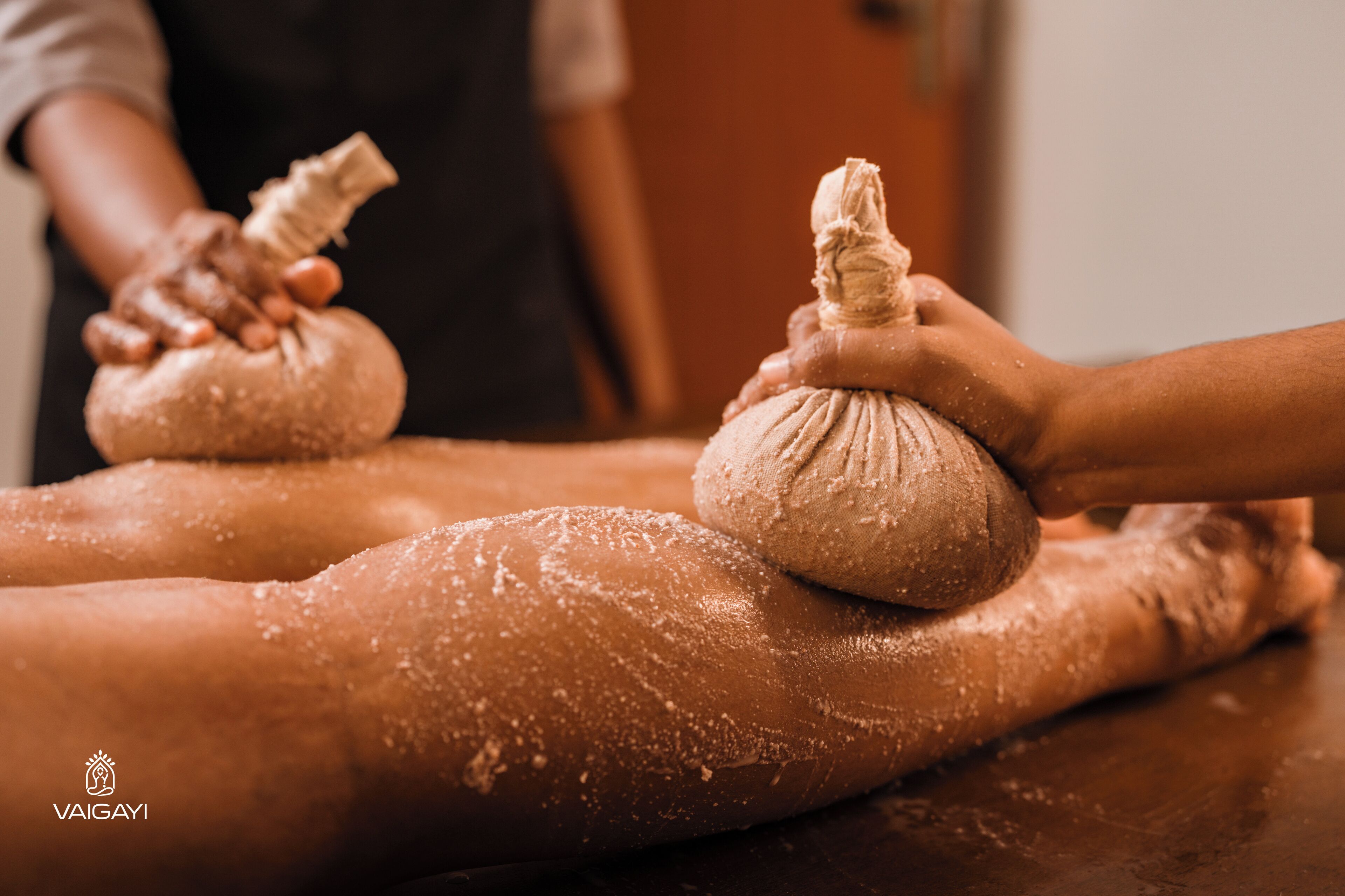 A massage session with a person applying a cloth to another's back.