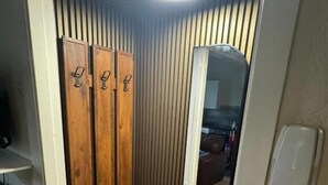 A compact room with a wooden wardrobe, a small bench, and a mirror. - Reads Avenue - Next To HA Social Club - Winter Gardens and Town Centre! (Blackpool)