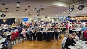 A large indoor dining area with numerous tables and chairs, a stage with lighting equipment, and a bar area in the background. - Reads Avenue - Next To HA Social Club - Winter Gardens and Town Centre! (Blackpool)