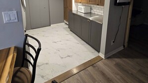 Eine kleine Küche mit Holzausstattung, einer Mikrowelle und einem eingebauten Backofen.