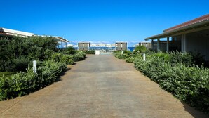 Un chemin menant à un bâtiment d’où l’on a une vue sur la mer.