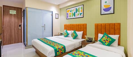 A hotel room with two beds, a wooden wardrobe, a door with a sign, and a framed abstract painting on the wall.