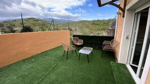 A patio with artificial grass, wicker furniture, and a view of a mountainous landscape. - 2 Rooms for 4 People (Ventiseri)