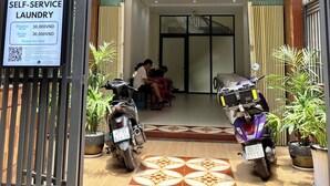 A self-service laundry facility with a sign indicating washing and drying services. - 21 Central Transit Stay | 4 Pax | Near MRT & Bus (Thành phố Hồ Chí Minh)