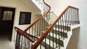 A staircase with wooden handrails and black metal railings, leading to an upper floor. - 21 Central Transit Stay | 4 Pax | Near MRT & Bus (Thành phố Hồ Chí Minh)