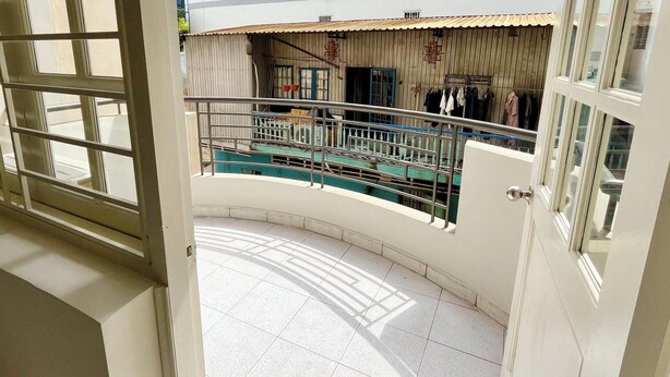 A balcony with a tiled floor, a metal railing, and a view of a building with clothes hanging outside. - 21 Central Transit Stay | 4 Pax | Near MRT & Bus (Thành phố Hồ Chí Minh)