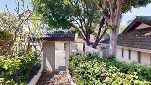 A traditional Japanese-style building with a tiled roof, surrounded by lush greenery and a stone pathway leading to the entrance. - mit Schwimmbad 10 Personen Koh Samui by Interhome (Koh Samui)