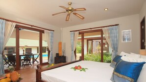 A bedroom with a wooden bed, a ceiling fan, and a view of a pool and outdoor area. - mit Schwimmbad 10 Personen Koh Samui by Interhome (Koh Samui)