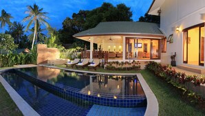 A swimming pool with lounge chairs, a covered patio, and a well-maintained garden. - Villa mit Blick auf das Wasser by Interhome (Koh Samui)