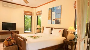A bedroom with a wooden bed, a TV, a window with a view of greenery, and a painting on the wall. - Villa mit Blick auf das Wasser by Interhome (Koh Samui)