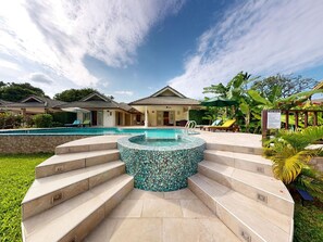 A swimming pool with a mosaic hot tub, surrounded by steps and lounge chairs. - am Strand by Interhome (Koh Samui)