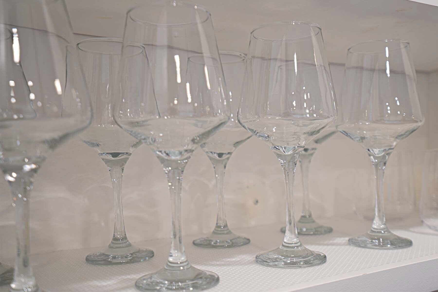 A row of empty wine glasses on a shelf.