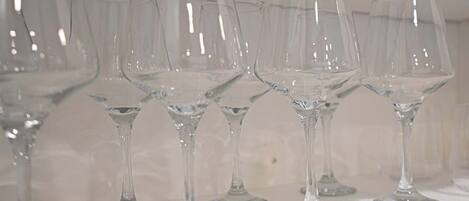 A row of empty wine glasses on a shelf.