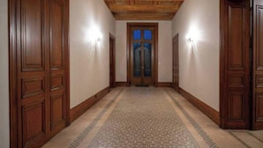 A hallway with wooden doors and patterned carpet. - Stay at the Château- Studio 2P- with pool and park (Fajolles)