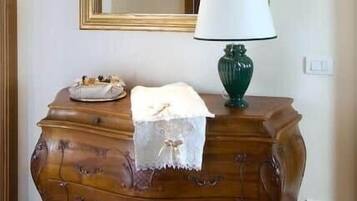 A wooden dresser with drawers, a mirror, and a green lamp.