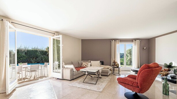 A spacious living area with a sofa, a red armchair, a coffee table, and a dining set. - Quiet House with Pool (Biot)
