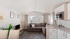 A compact living space with a sofa, TV, and kitchenette.