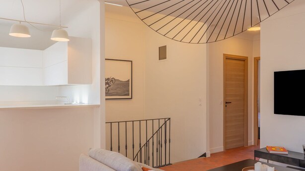 A modern living room with a sofa, a coffee table, a TV, and a staircase leading to another room. - Saint-Tropez: Bright apartment near the port (Saint-Tropez)