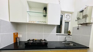 Una cucina con un piano di lavoro nero, mobili in legno, un fornello e un lavandino.