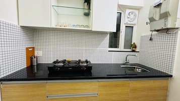 Kjøleskap, kokeplater, kjøkkenutstyr og spisebord