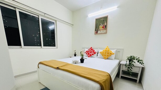 Una camera da letto con un letto, un comodino, una finestra e un quadro appeso al muro.