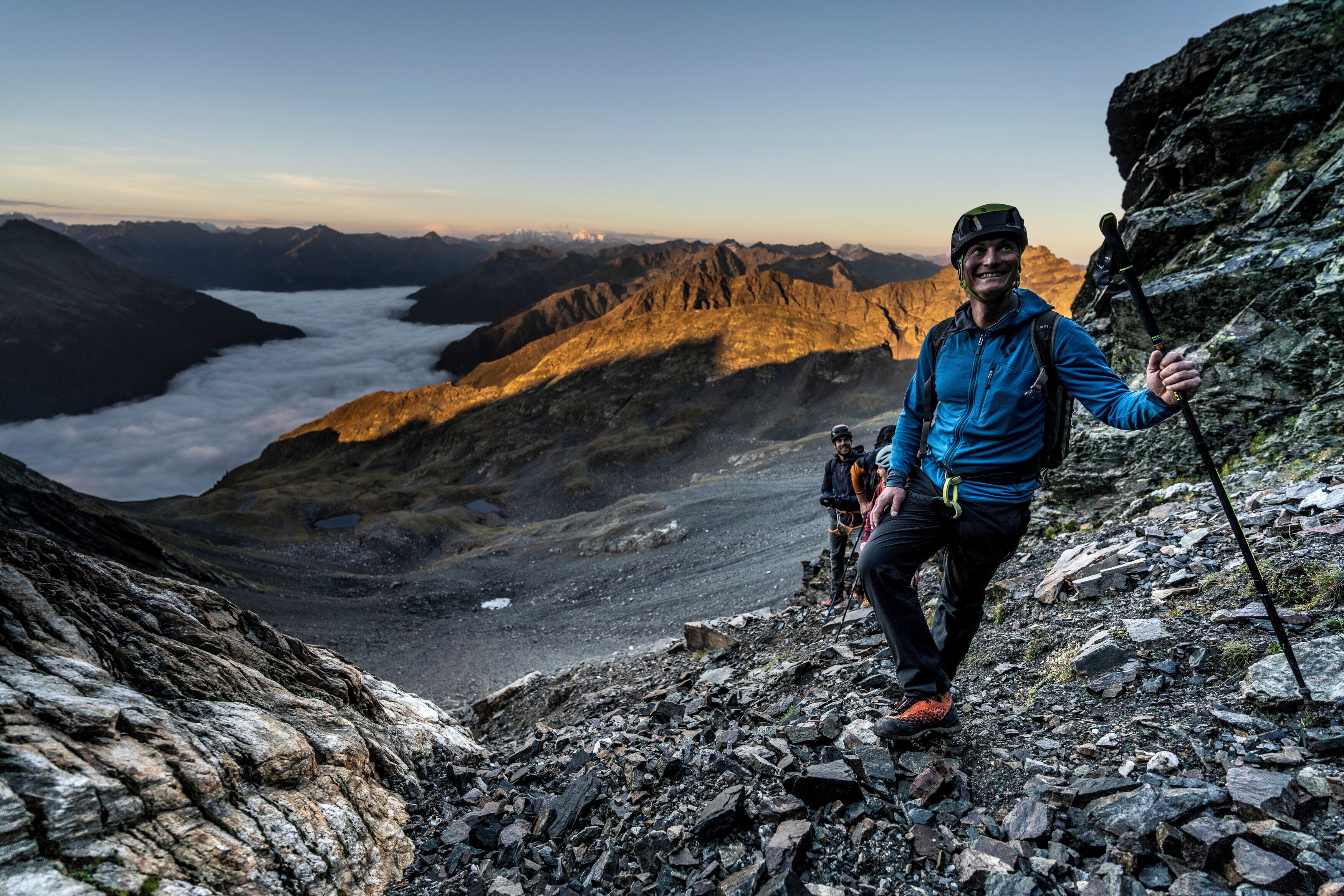A mountainous landscape with rocky terrain and a person hiking.