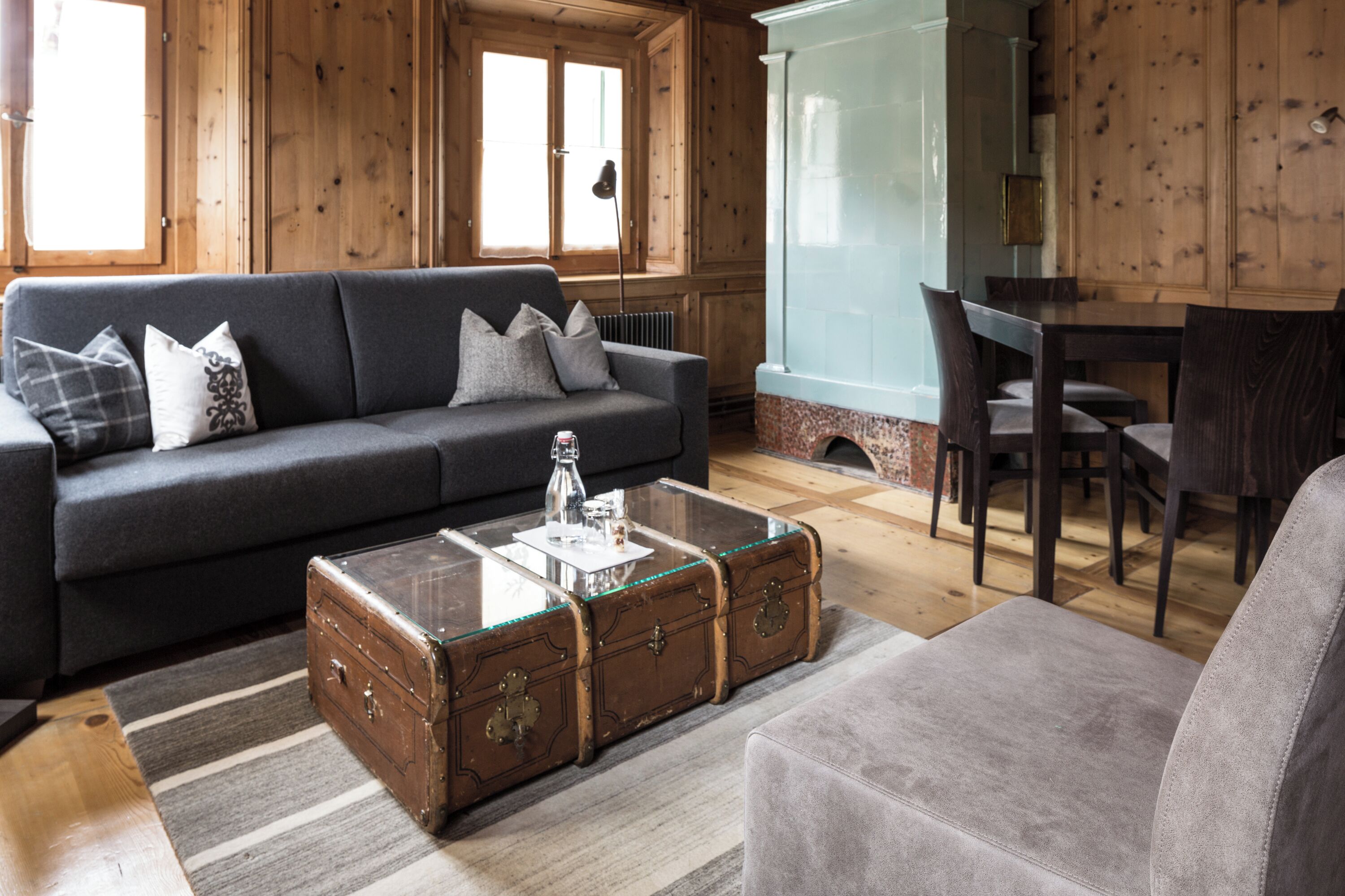 A cozy room with a sofa, a glass-top coffee table, and a wooden chest of drawers.