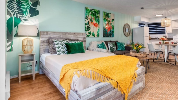 Un dormitorio moderno con cama, mesita de noche y pequeño espacio de escritorio.
