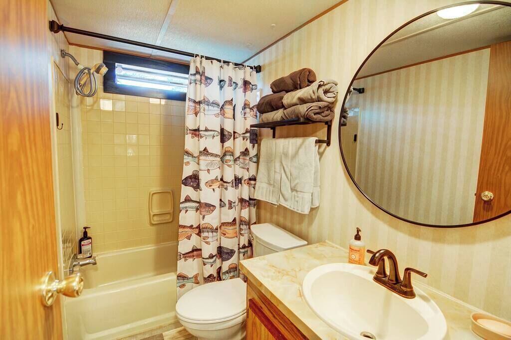 Une petite salle de bain comprenant une baignoire, des toilettes et un lavabo.