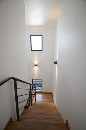 A staircase with wooden steps, black handrails, and a wall-mounted light fixture. - Luxury Escape – 5-Star Villa Just 200m from Trou aux Biches Beach (Trou aux biches)