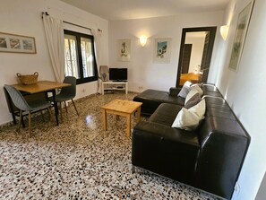 A living room with a sofa, a TV, a table, and a chair. - Villa Buena Vista with sea views, private pool, WiFi, air conditioning (Calpe)