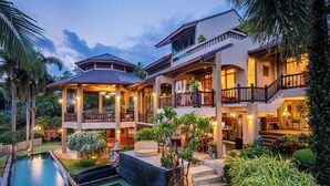 A multi-story house with a pool, outdoor seating, and lush landscaping. - Bell Seaside Luxury Villa (Rawai)