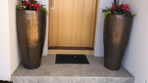 Una puerta de madera con un felpudo metálico en el frente.
