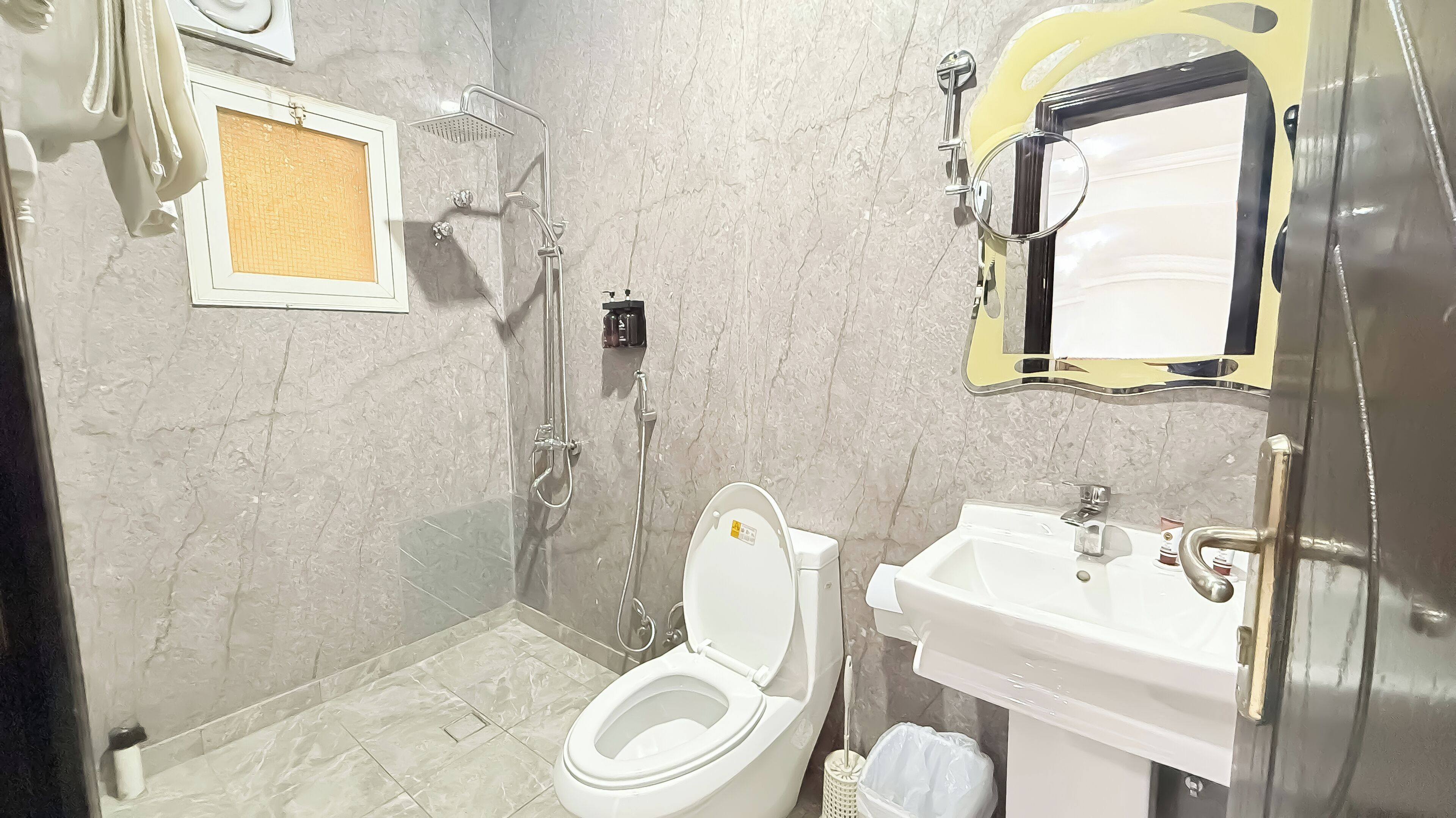 Une salle de bain avec des toilettes, un lavabo et une douche.