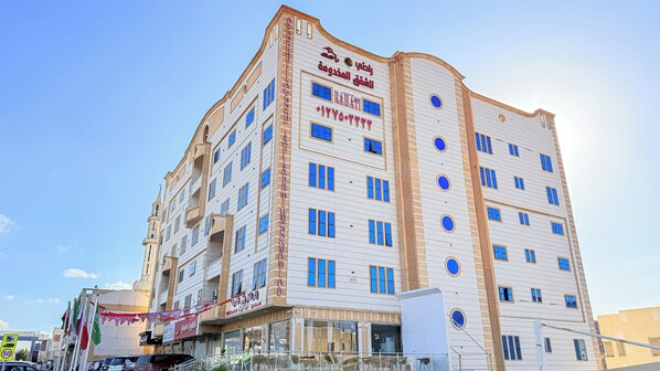 A multi-story building with a sign indicating it is a serviced apartment complex. - Rahati Serviced Apartments (Taif)