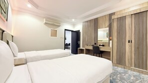A hotel room with two beds, a desk, a mirror, and a wardrobe. - Rahati Serviced Apartments (Taif)
