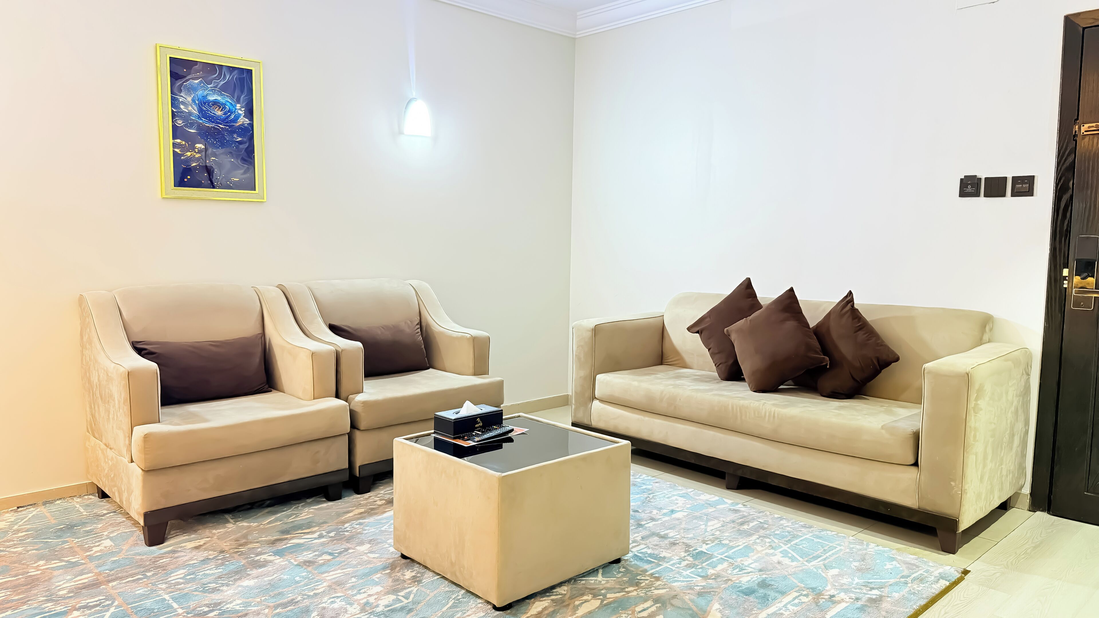 A living room with two beige sofas, a coffee table, and a painting on the wall.