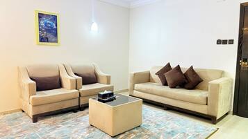 A living room with two beige sofas, a coffee table, and a painting on the wall.
