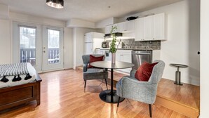 Een modern appartement met een eethoek, een keuken en een balkon.