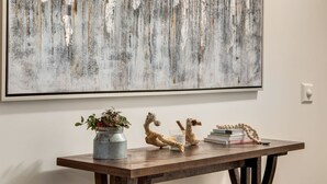 Een houten tafel met een plant, een paardbeeldje en een stapel boeken.