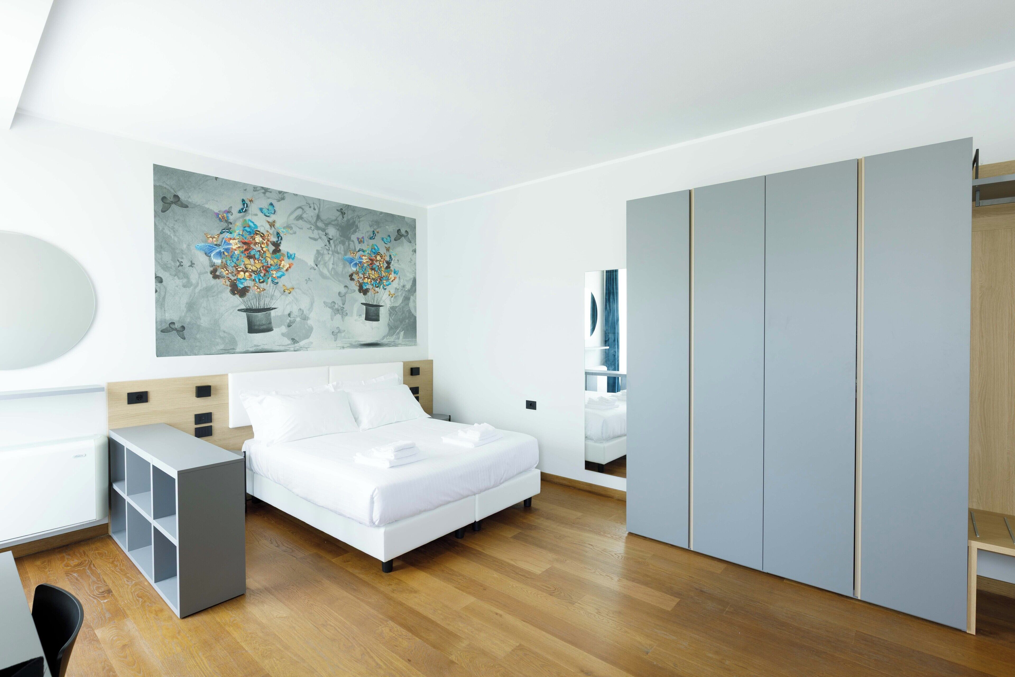 Een moderne slaapkamer met een bed, een bureau en een kledingkast.