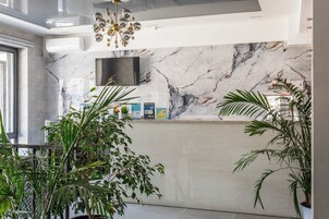 A modern kitchen with a marble backsplash, a built-in TV, and various kitchen appliances.
